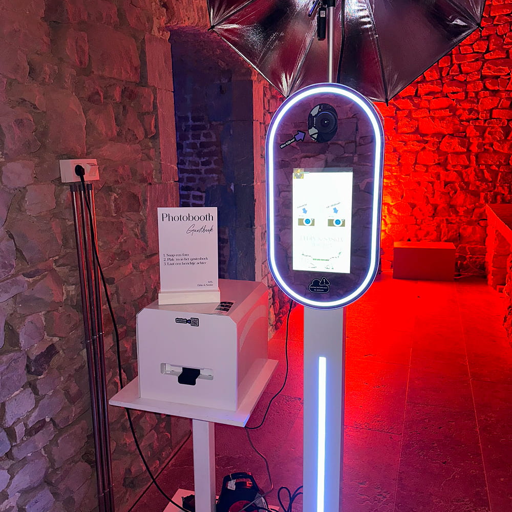 Luxe photobooth zuil met printer in een kelderzaal met rood licht